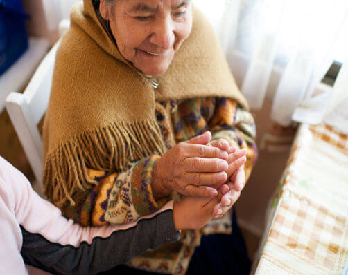 Elderly person holding younger person's hand